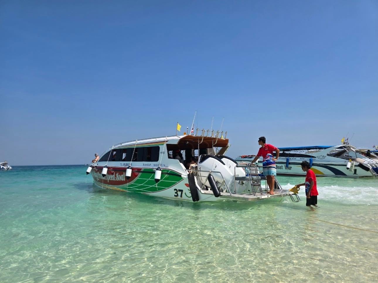 Speedboat anchored near Maya Bay's turquoise waters and limestone cliffs on a Krabi island tour