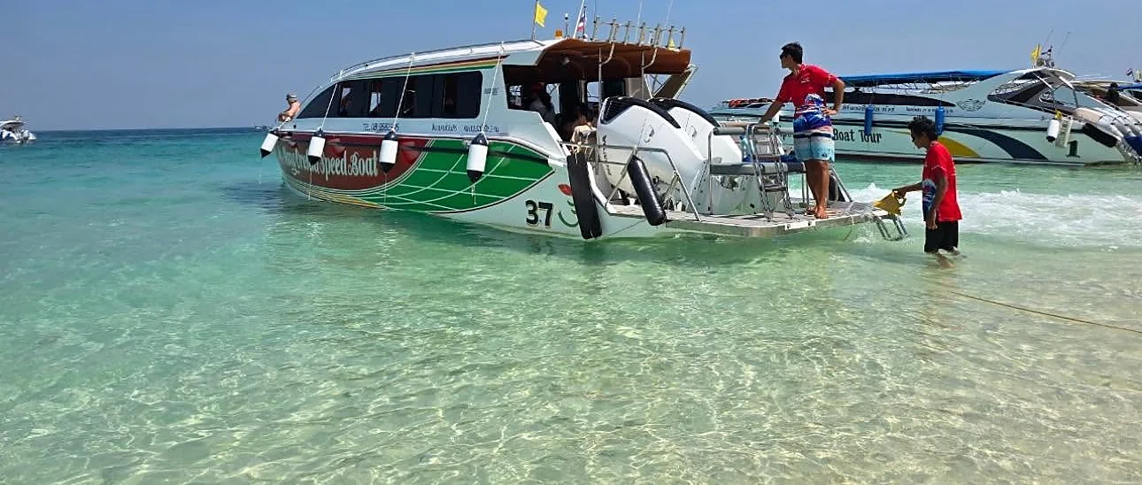Speedboat anchored near Maya Bay's turquoise waters and limestone cliffs on a Krabi island tour