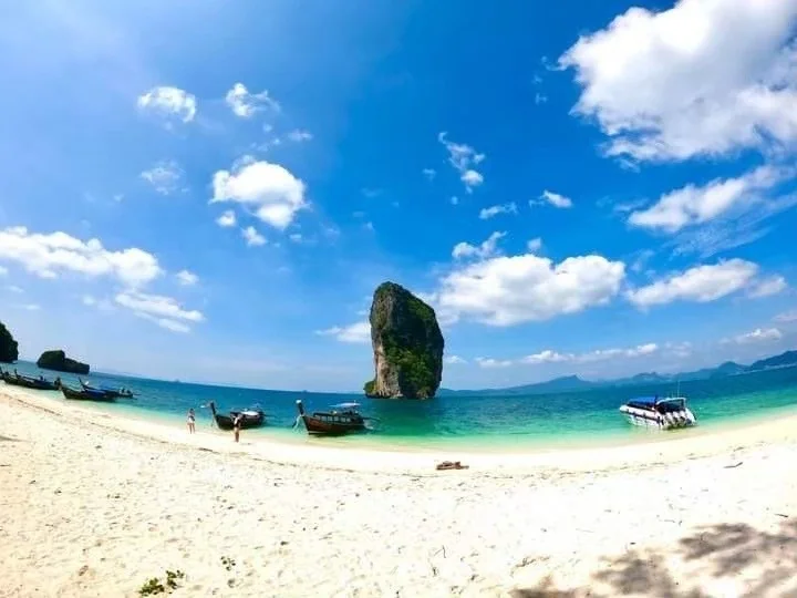 Longtail boat anchored near Koh Poda's turquoise waters and limestone cliffs on a Krabi 4 Island Tour
