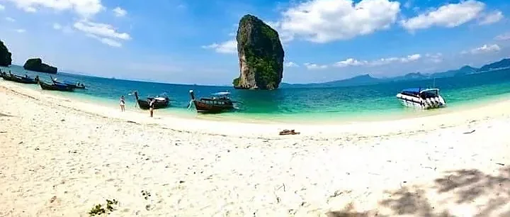 Longtail boat anchored near Koh Poda's turquoise waters and limestone cliffs on a Krabi 4 Island Tour