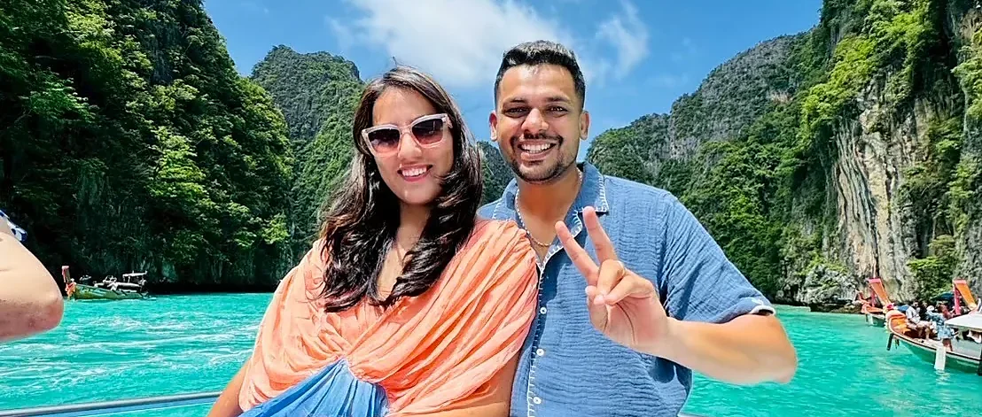 Speed boat arriving at Phi Phi Island with turquoise waters and towering limestone cliffs on a sunny day