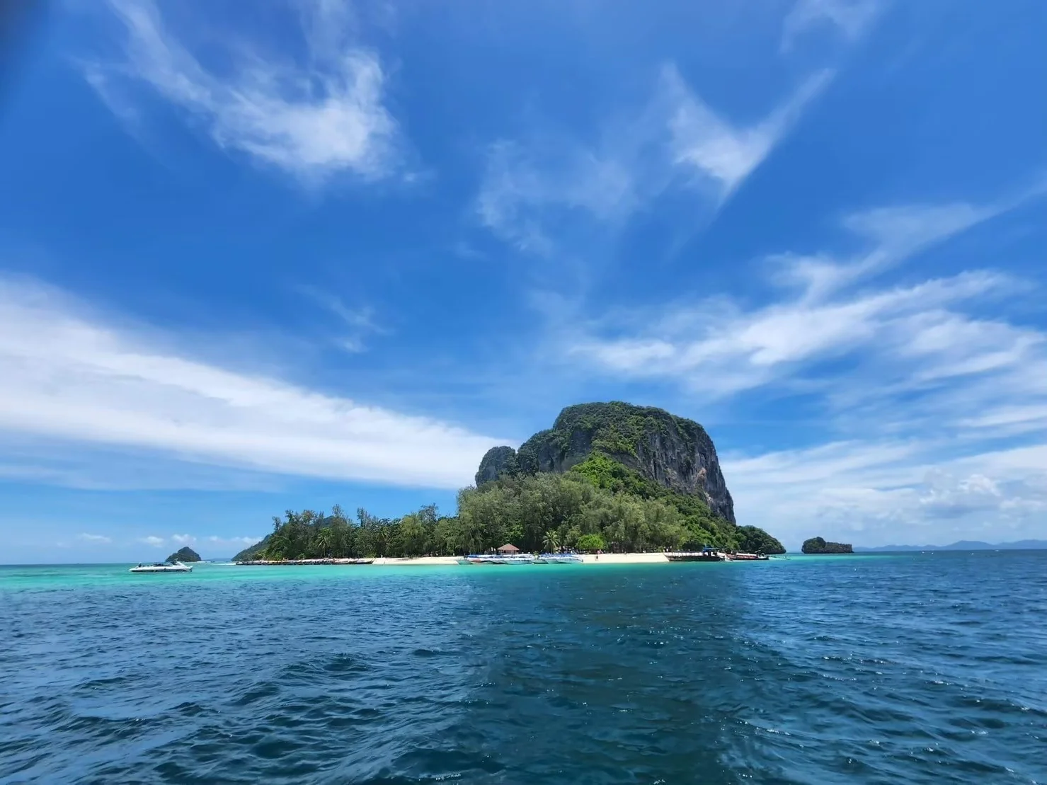 Speed boat gliding past dramatic limestone cliffs on a 4 Island Tour in Krabi, Thailand