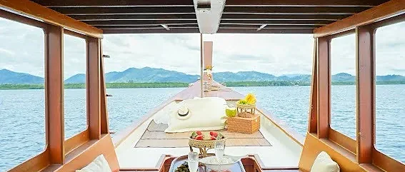 Traditional long-tail boat gliding through Phang Nga mangrove tunnels on a local life tour