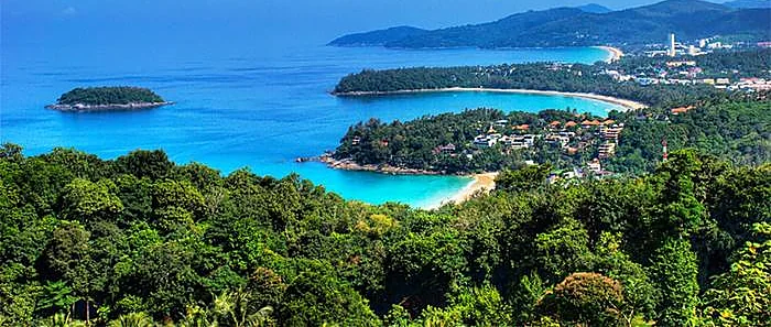Panoramic view of Phuket's coastline from Karon Viewpoint, showing turquoise bays and lush green hills