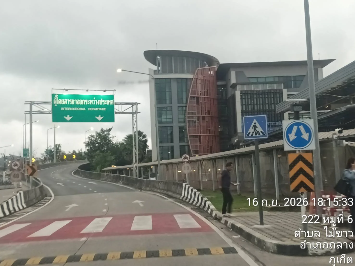 International departures entrance road at Phuket International Airport under cloudy skies