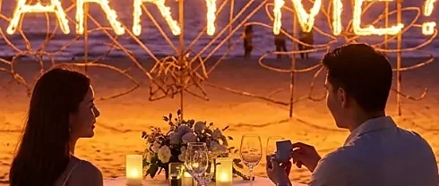 Romantic beachfront proposal setup in Phuket with rose petals, candles, and tropical ocean views at sunset