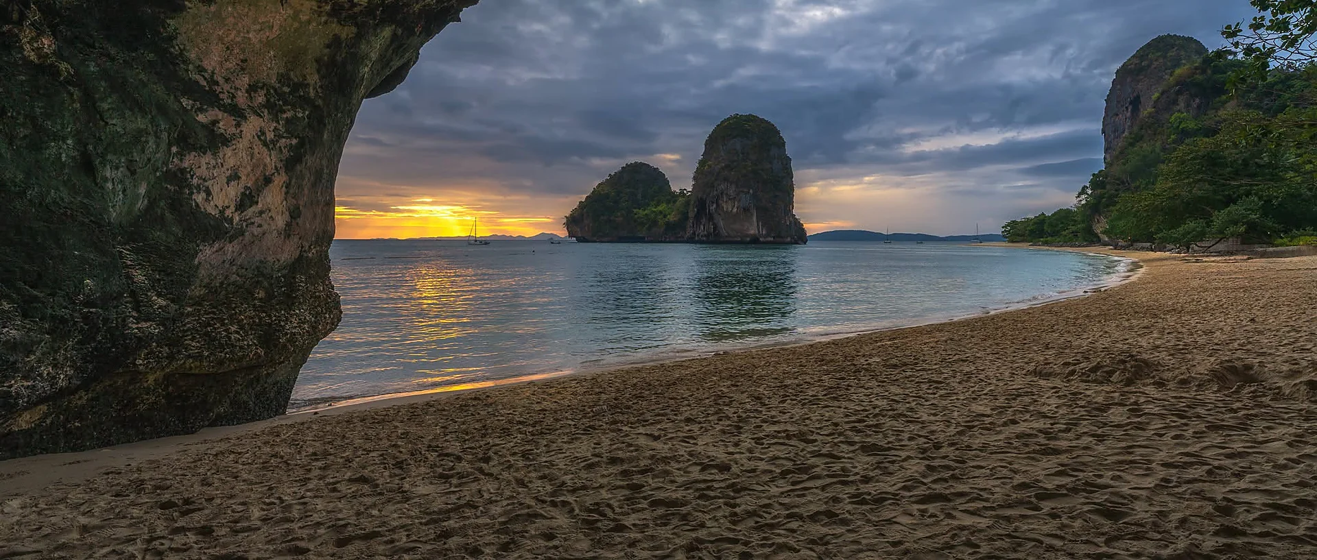 Long-tail boat off Railay Beach at sunset on a bioluminescent plankton tour in Krabi