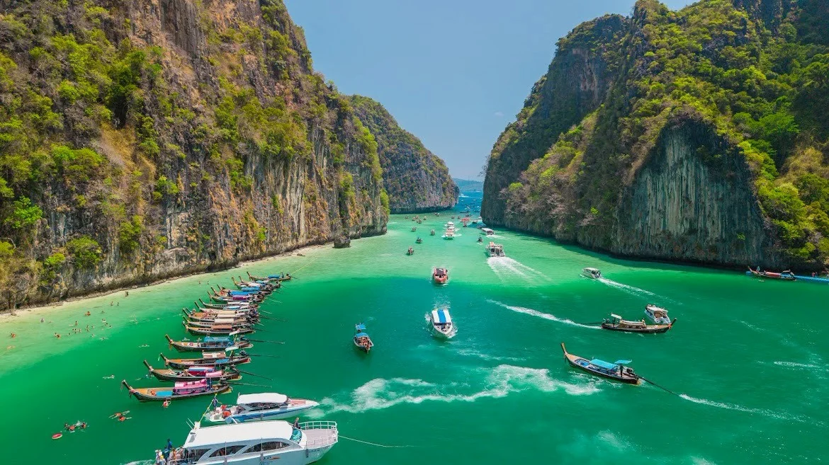 Turquoise waters and dramatic limestone cliffs surrounding Phi Phi Island on a sunny day