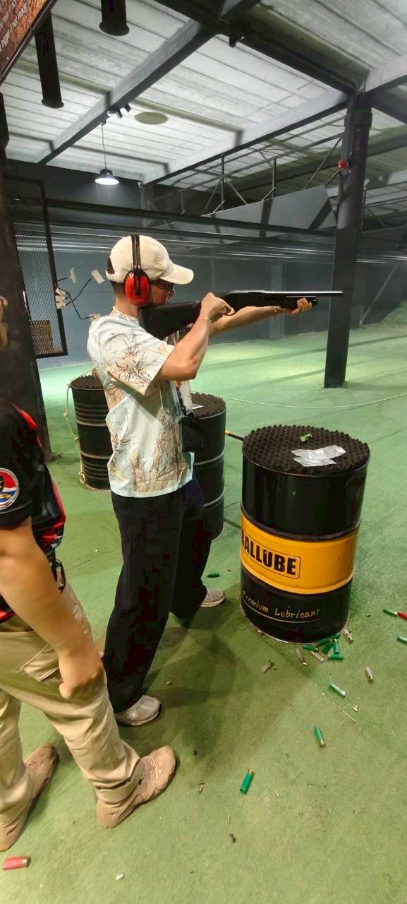 Traveler aiming a shotgun at Top Hill shooting range in Phuket