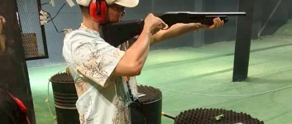 Traveler aiming a shotgun at Top Hill shooting range in Phuket