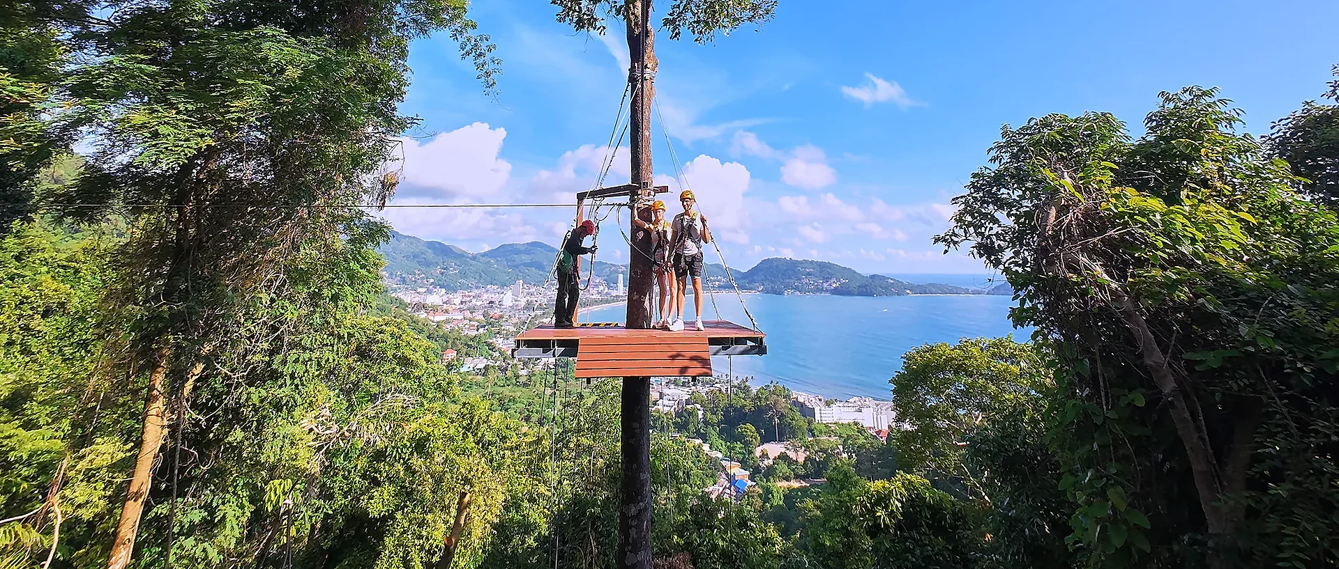 Aerial zipline ride above Patong's lush jungle canopy with panoramic sea views stretching to the horizon