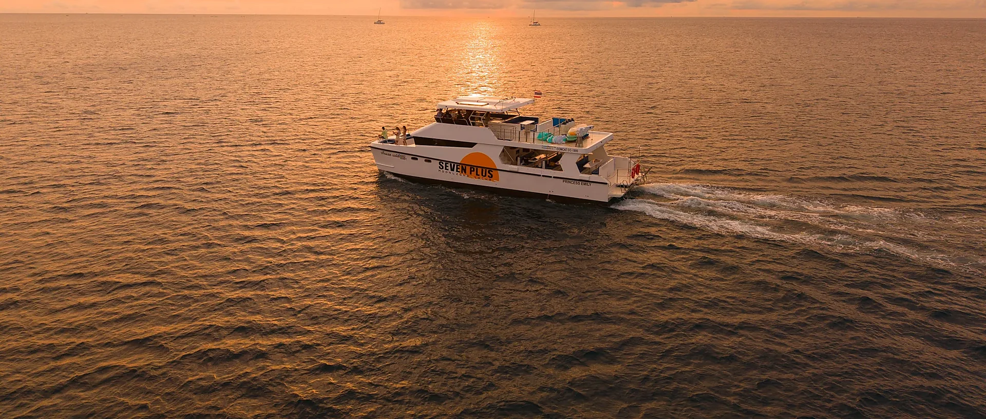 Emily Moonlight Plus luxury cruise sailing past dramatic limestone cliffs at Phi Phi Leh at dusk