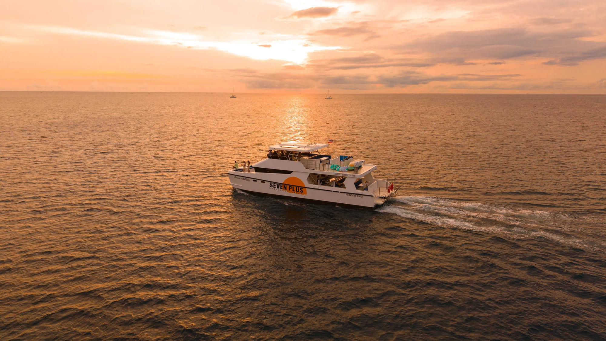 Emily Moonlight Plus luxury cruise sailing past dramatic limestone cliffs at Phi Phi Leh at dusk