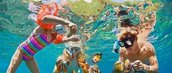 Crystal-clear turquoise waters and white sand beach at Racha Island, Phuket, on a sunny speedboat day tour