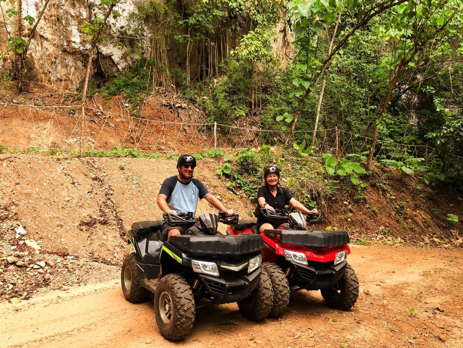 Rider steering an ATV through a jungle trail in Krabi, with lush greenery on either side
