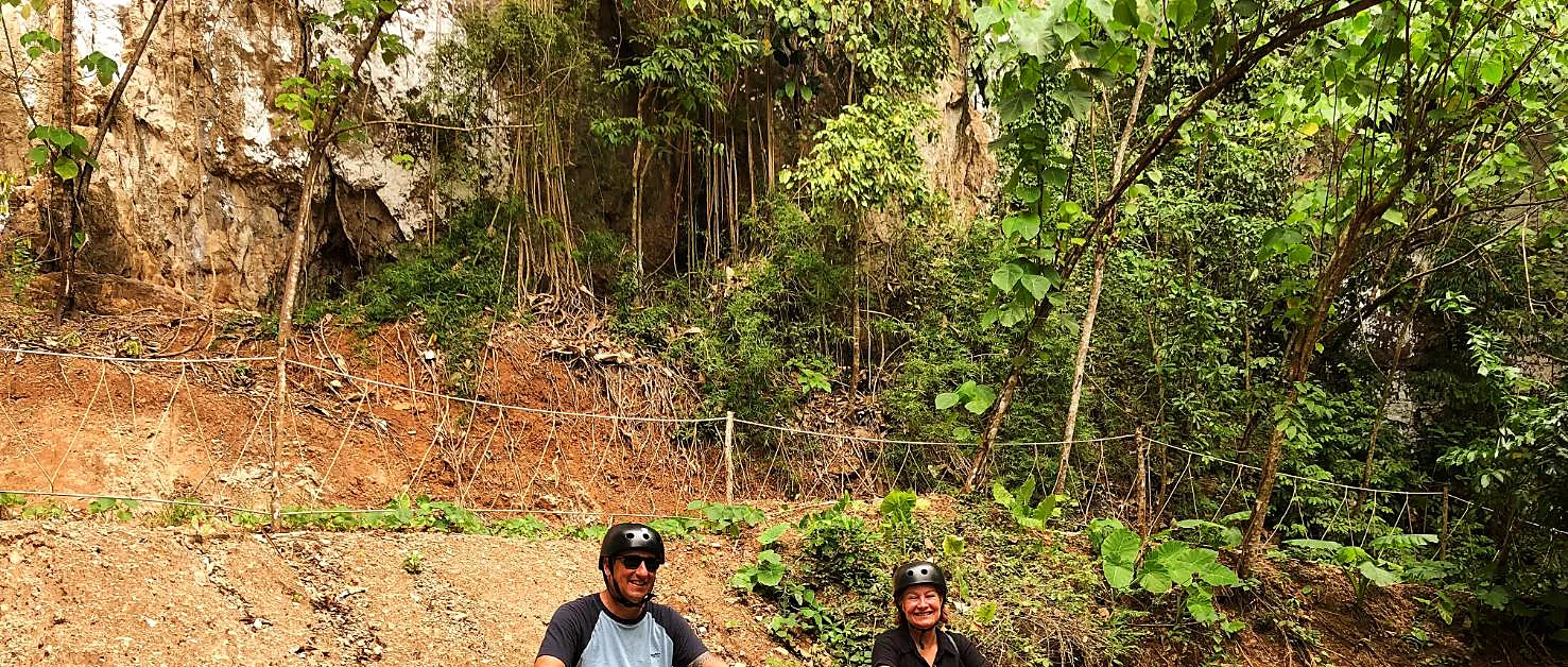 Rider steering an ATV through a jungle trail in Krabi, with lush greenery on either side