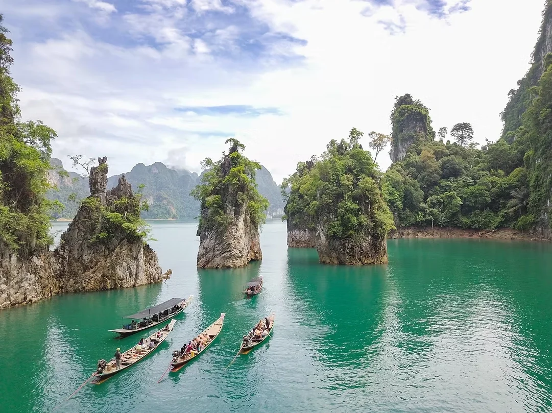 Dramatic limestone karsts rise above the emerald waters of Cheow Lan Lake in Khao Sok National Park