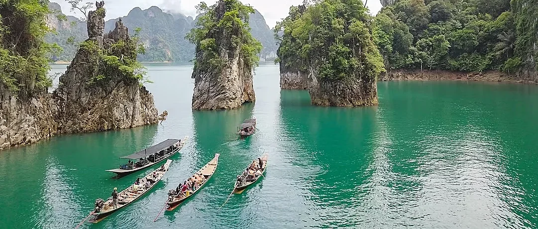 Dramatic limestone karsts rise above the emerald waters of Cheow Lan Lake in Khao Sok National Park