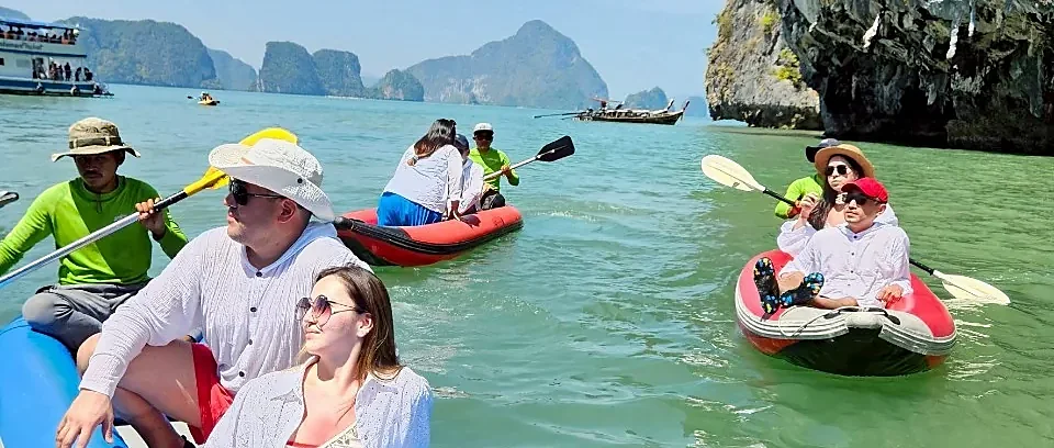 Speed boat gliding past the iconic limestone karsts of Phang Nga Bay on a James Bond Island sea canoe tour