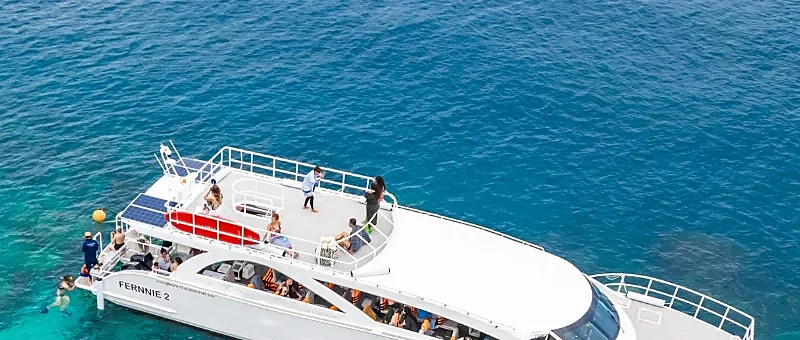 Speed catamaran cruising toward Phi Phi Island and Maya Bay on crystal-clear turquoise Andaman waters