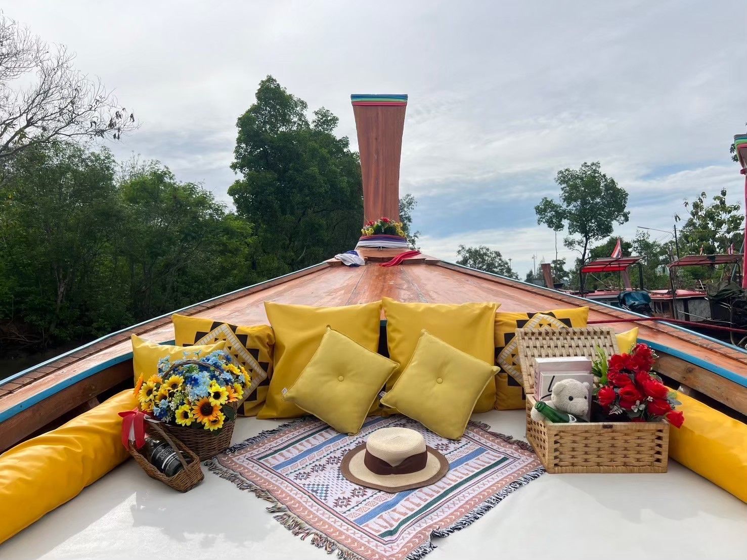 Decorated Phuket longtail boat with yellow cushions, flowers, gift basket and straw hat