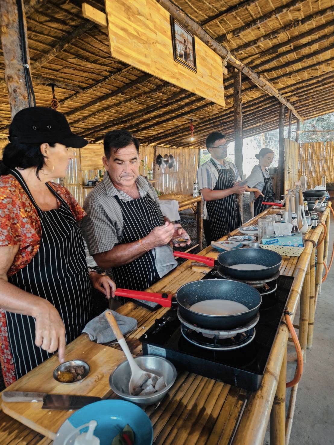 Guests prepare traditional Thai dishes during a hands-on cooking class on Samui Island