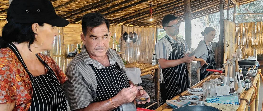 Guests prepare traditional Thai dishes during a hands-on cooking class on Samui Island