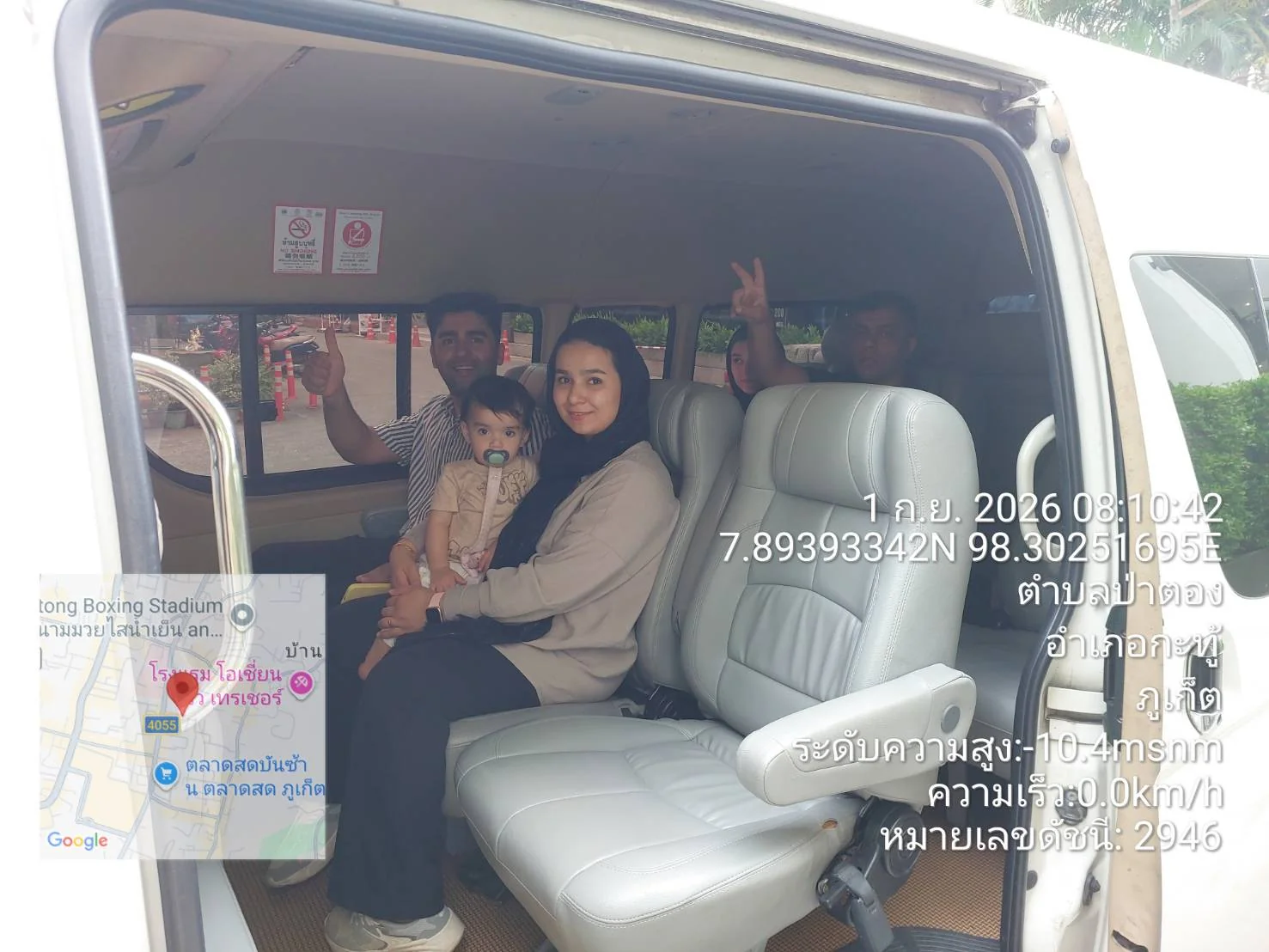 Happy family with a baby seated inside a private transfer van in Patong, Phuket