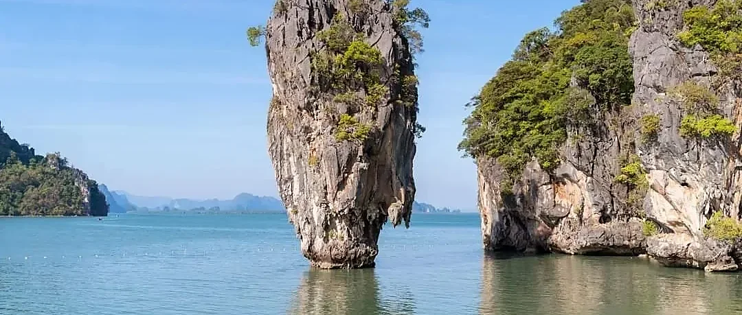 Scenic Phuket coastline with turquoise waters and lush green hills on a sunny 4-day land package tour
