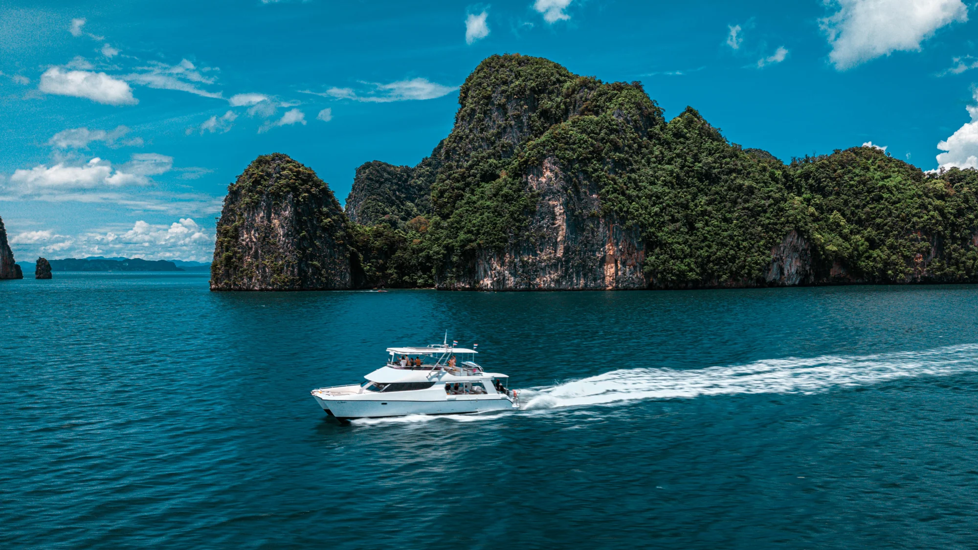 Luxury yacht anchored near dramatic limestone karsts in Phang Nga Bay on the James Bond Island tour