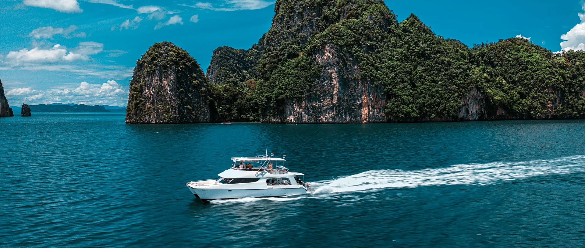 Luxury yacht anchored near dramatic limestone karsts in Phang Nga Bay on the James Bond Island tour