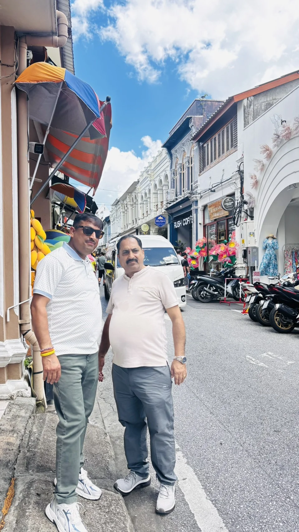 Two guests posing on a colorful heritage street in Phuket Old Town, Thailand